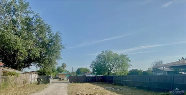 a view of a backyard with wooden fence