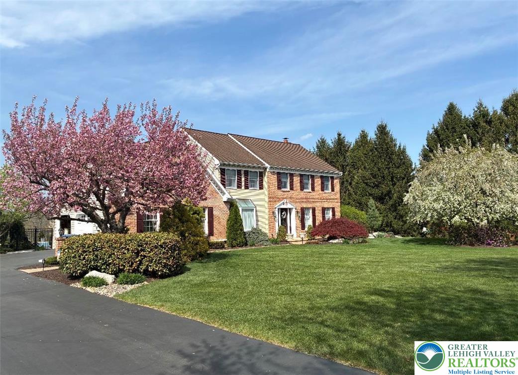 4059 Old Sentry Road Allentown, PA 18104 - Photo 2 of 39 A well-maintained lawn and vibrant flowering trees highlight this classic brick residence.
