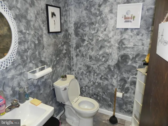 a white toilet sitting next to a bathroom sink