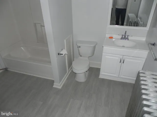 a bathroom with a toilet sink and a mirror