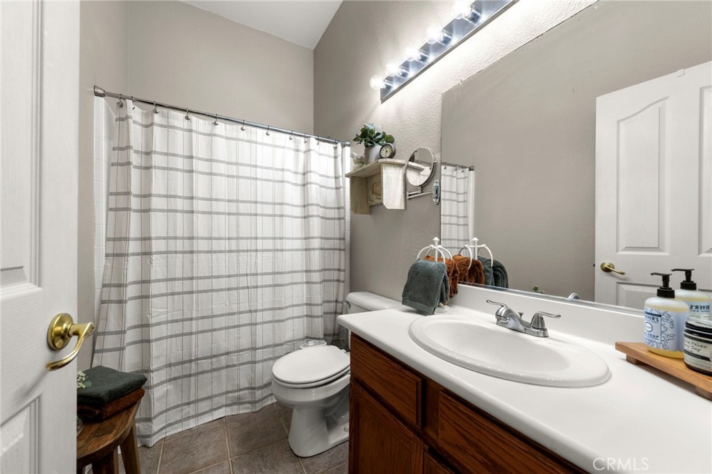 34423 Desert Road Acton, CA 93510 - Photo 29 of 53 a bathroom with a sink a toilet and shower curtain