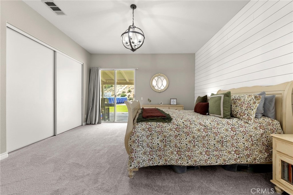 34423 Desert Road Acton, CA 93510 - Photo 32 of 53 a bedroom with a large bed and a chandelier