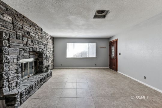 301 South Lincoln Street Ridgecrest, CA 93555 - Photo 5 of 20 a view of an empty room with a fireplace and a window