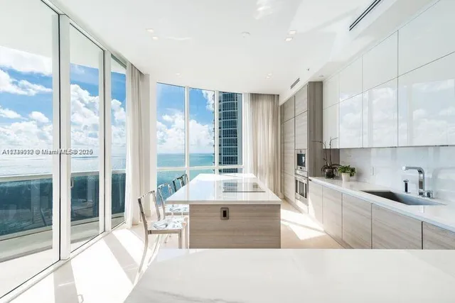 a large kitchen with kitchen island a large window in it