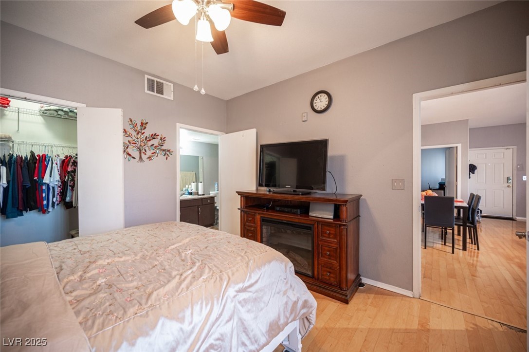 6650 West Warm Springs Road, Unit 1079 Las Vegas, NV 89118 - Photo 19 of 37 Bedroom featuring visible vents, a closet, baseboards, a ceiling fan, and light wood-style flooring