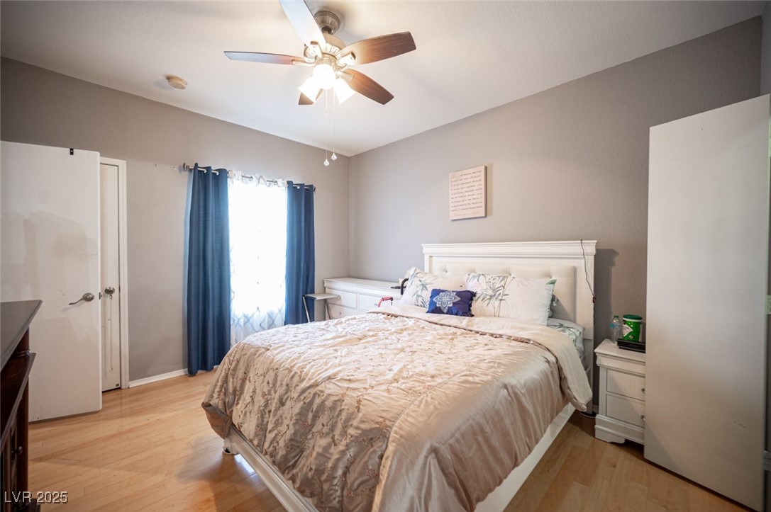 6650 West Warm Springs Road, Unit 1079 Las Vegas, NV 89118 - Photo 20 of 37 Bedroom with light wood-style flooring and ceiling fan