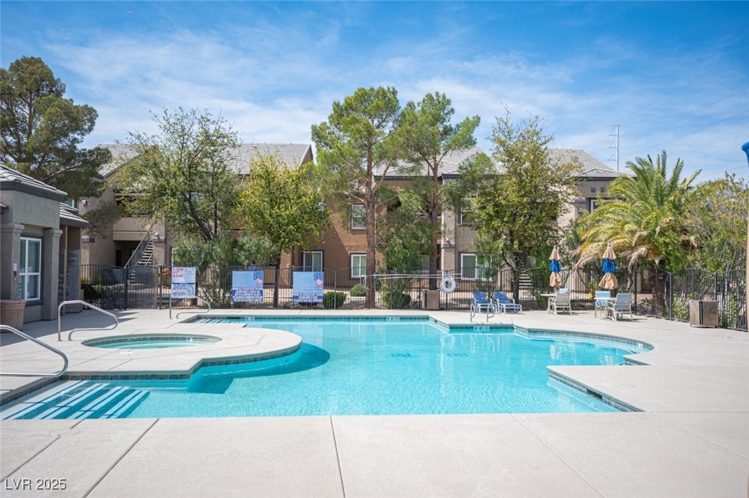 6650 West Warm Springs Road, Unit 1079 Las Vegas, NV 89118 - Photo 35 of 37 Community pool featuring a patio area, a community hot tub, and fence