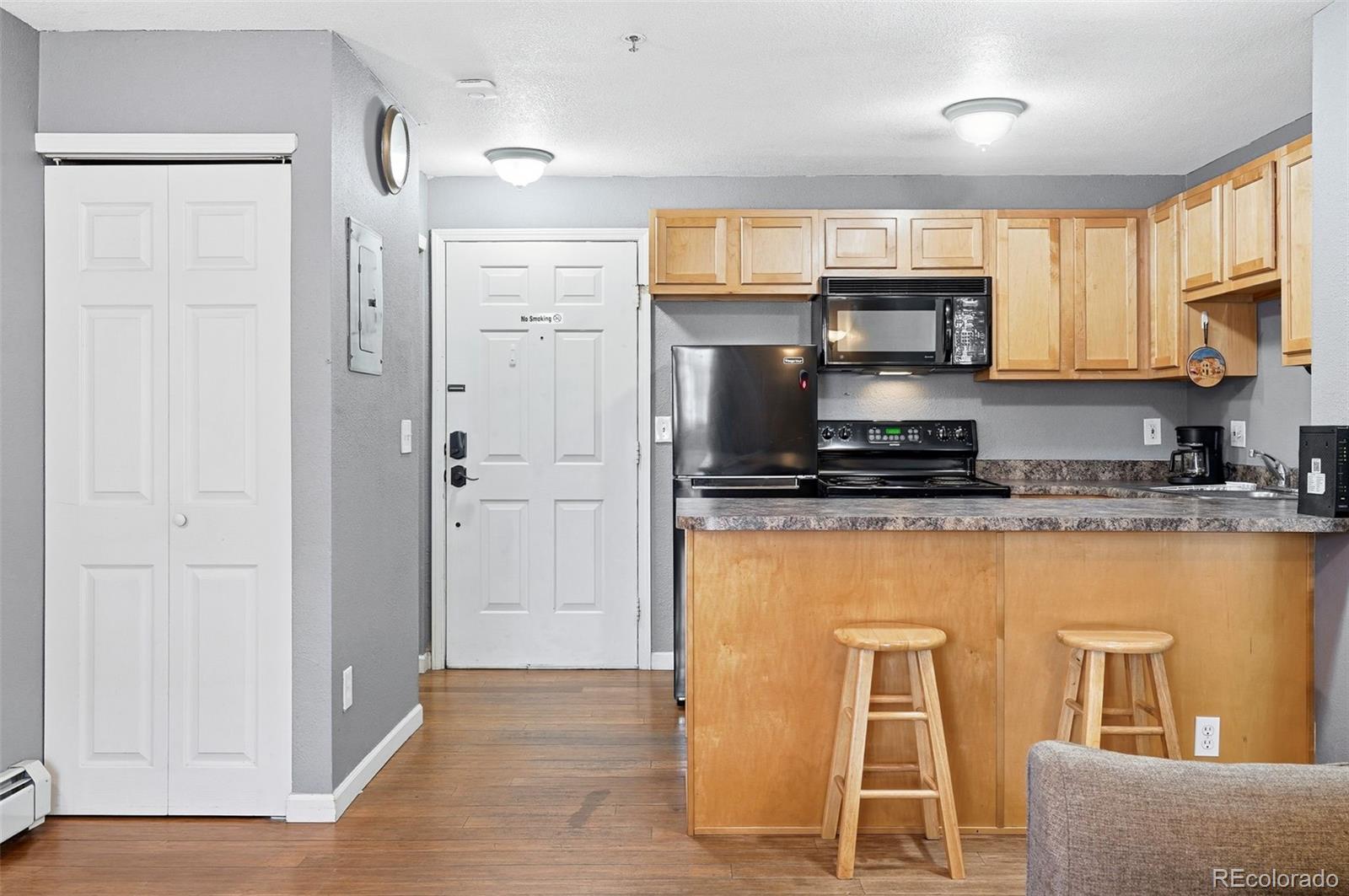 1405 Broadway, Unit 206 Boulder, CO 80302 - Photo 15 of 47 a kitchen with kitchen island granite countertop a refrigerator stove microwave and sink