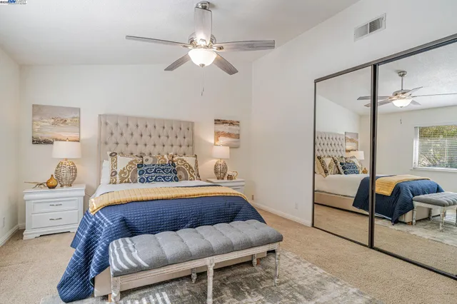 a bedroom with a bed and ceiling fan