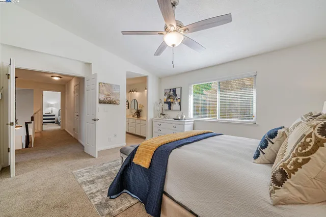 a spacious bedroom with a bed and a chandelier