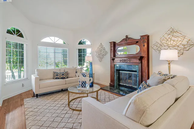 a living room with furniture a fireplace and a large window