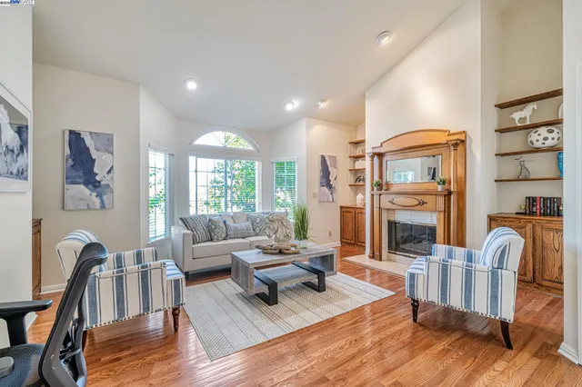 a living room with fireplace furniture and a wooden floor