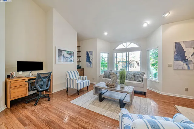 a living room with furniture a flat screen tv and wooden floor