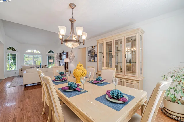a view of a dining room with furniture a chandelier and wooden floor