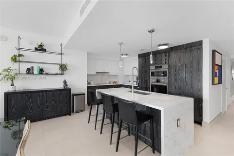 a kitchen with kitchen island a stove a table and chairs in it