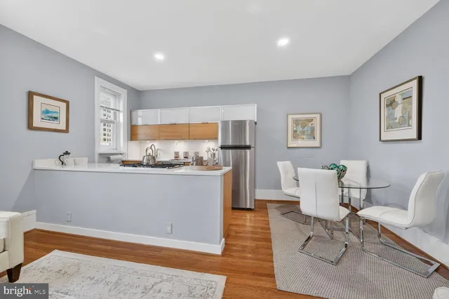 a living room with furniture a rug and white walls