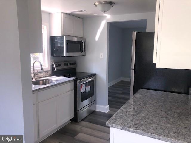 8535 Neptune Drive Pasadena, MD 21122 - Photo 3 of 7 a kitchen with a sink and a stove top oven