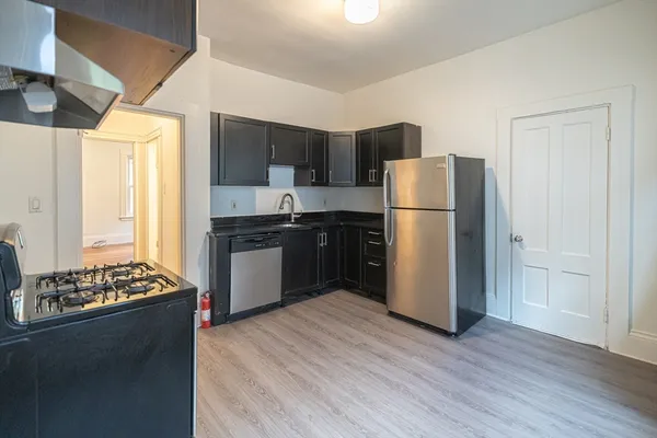 a kitchen with a refrigerator and a stove top oven