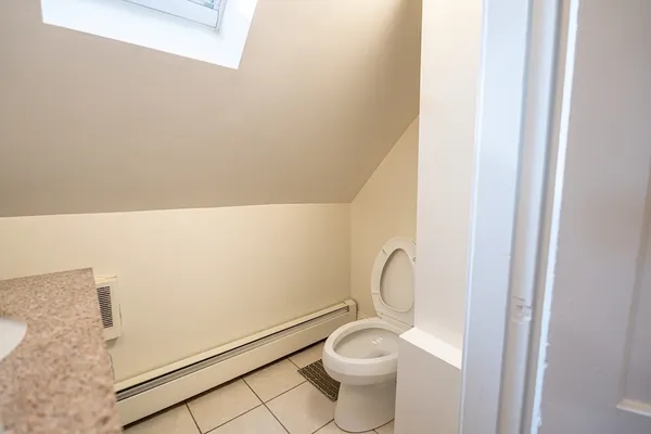a white toilet sitting next to a shower