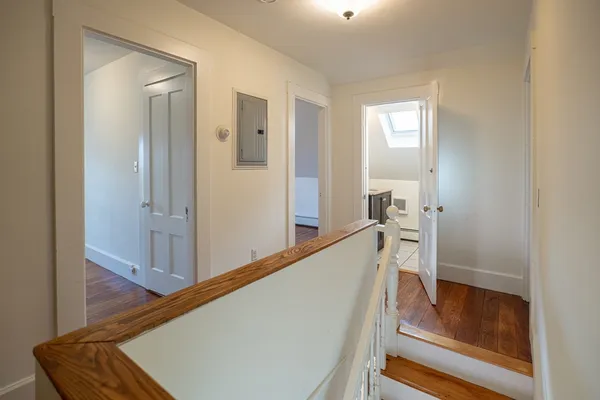 a view of hallway with furniture and wooden floor