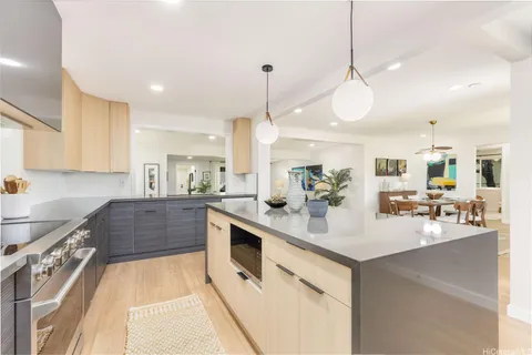 a kitchen with kitchen island granite countertop a sink a counter space appliances and cabinets