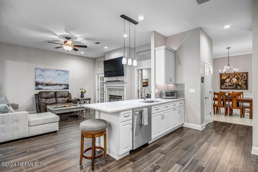 757 Mill Stream Road Ponte Vedra Beach, FL 32082 - Photo 25 of 65 a kitchen with stainless steel appliances a stove a sink dishwasher a oven with white cabinets and wooden floor