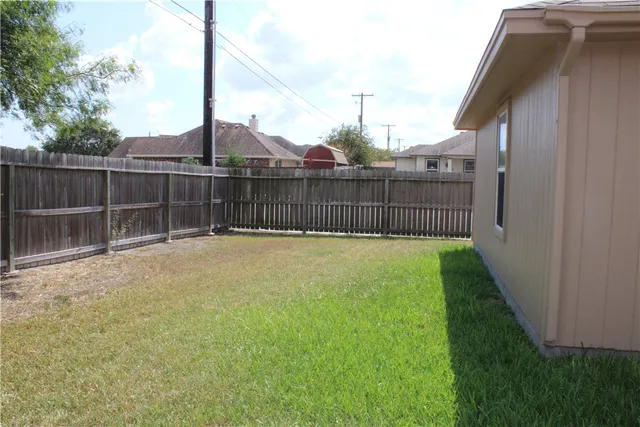 a view of an house with backyard and tub