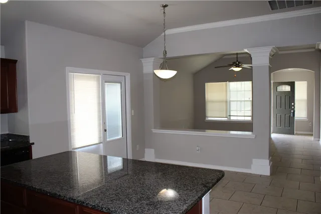 a kitchen with granite countertop sink and window