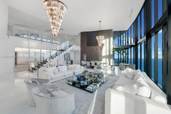 a living room with furniture a chandelier and a chandelier