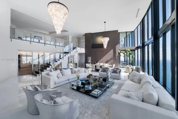 a living room with furniture and a chandelier