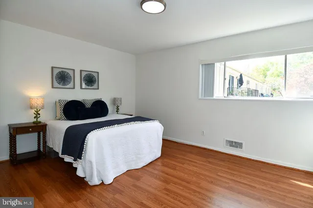 a bedroom with a bed and wooden floor