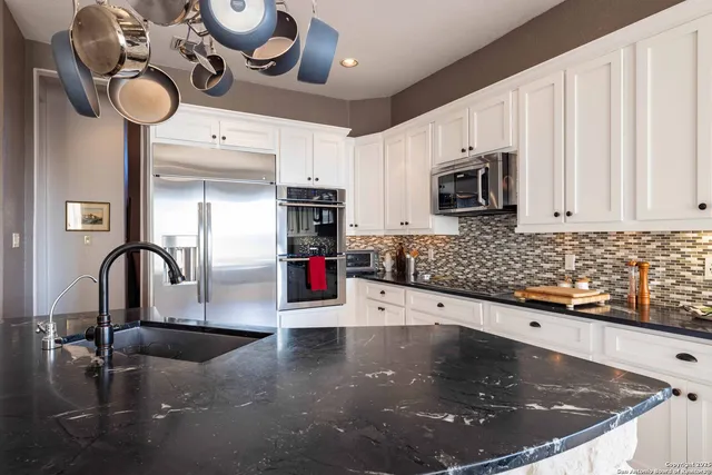 a kitchen with stainless steel appliances granite countertop a sink a stove and a microwave