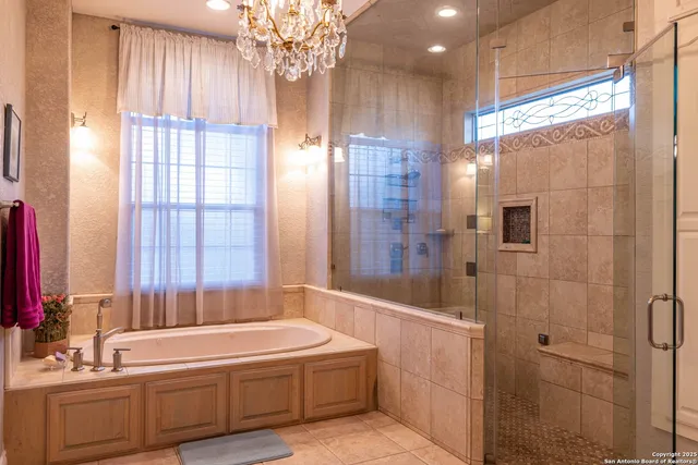 a bathroom with a granite countertop sink a large mirror a shower and a bathtub