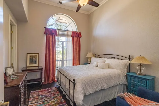 a bedroom with a bed a chandelier and a dresser