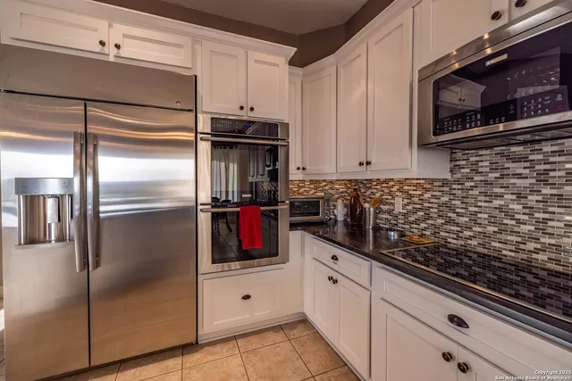 a kitchen with white cabinets and stainless steel appliances