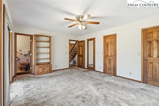 a view of an empty room with closet and a window