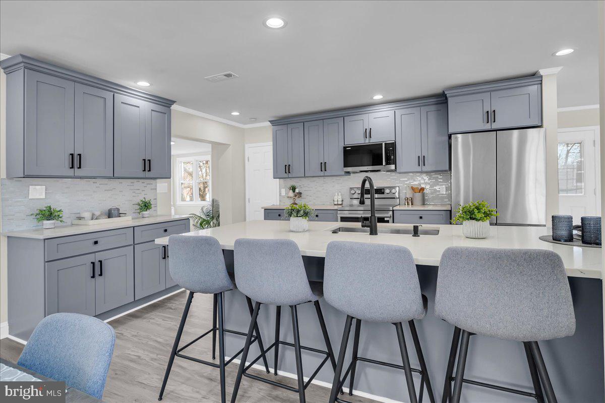 12 West Dale Road Wilmington, DE 19810 - Photo 16 of 44 a kitchen with stainless steel appliances granite countertop a dining table chairs a refrigerator a stove a microwave and cabinets