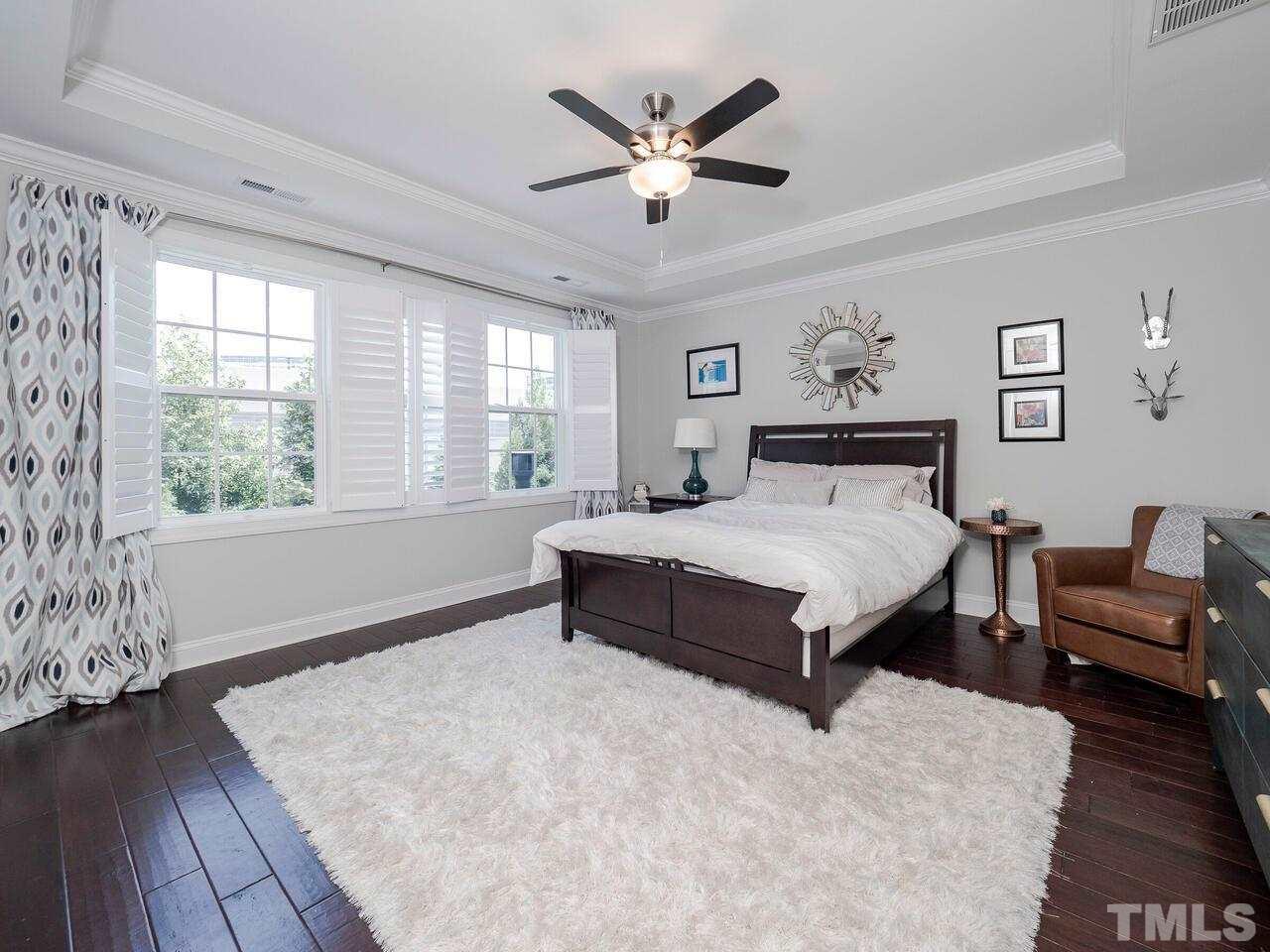 3936 Ivory Rose Lane Raleigh, NC 27612 - Photo 8 of 12 a spacious bedroom with a bed and a large window