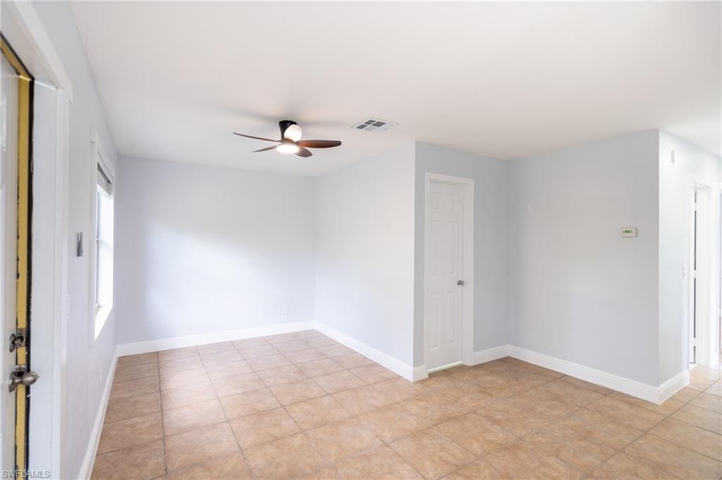 1940 48th Street Southwest Naples, FL 34116 - Photo 21 of 33 Bright interior space featuring light-colored walls, tile flooring, a ceiling fan with integrated lighting, and multiple windows