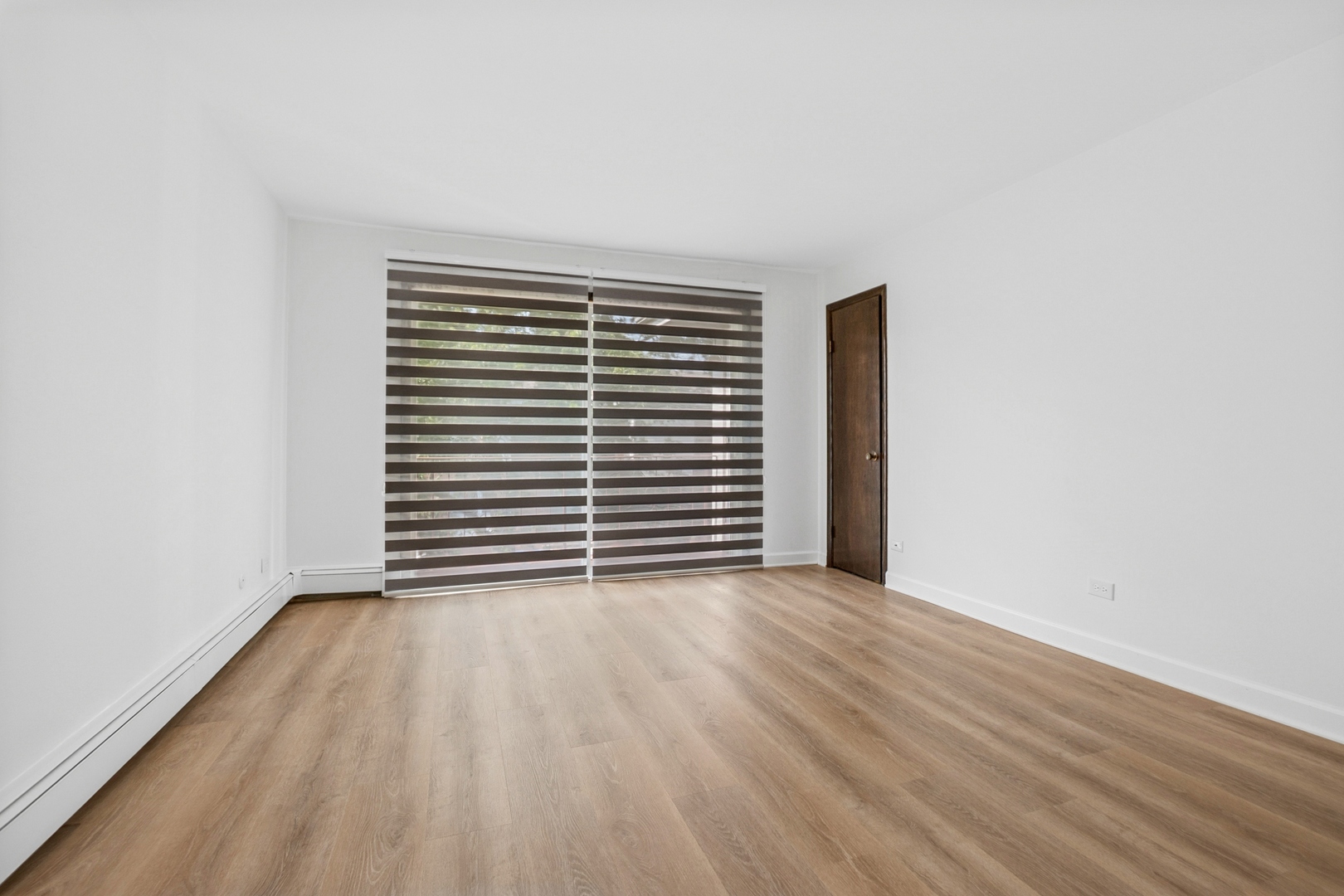 15290 El Cameno Terrace, Unit 2W Orland Park, IL 60462 - Photo 5 of 14 a view of an empty room with wooden floor and a window