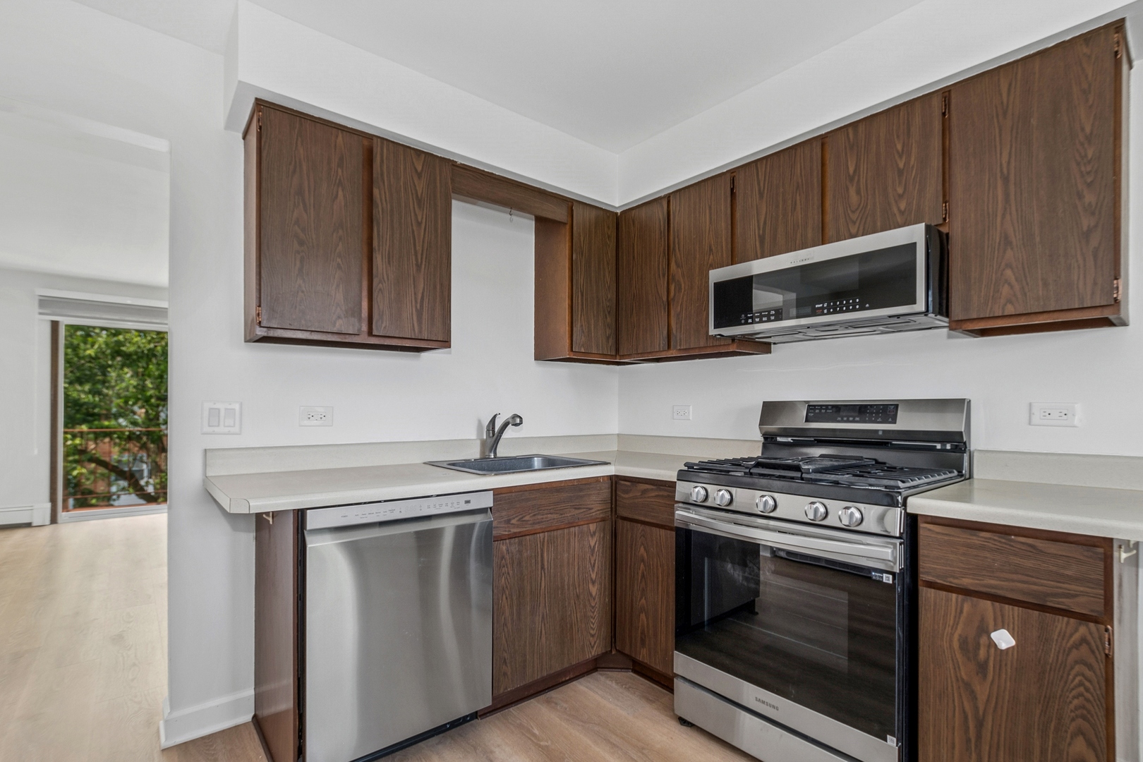 15290 El Cameno Terrace, Unit 2W Orland Park, IL 60462 - Photo 7 of 14 a kitchen with cabinets stainless steel appliances a sink and a microwave