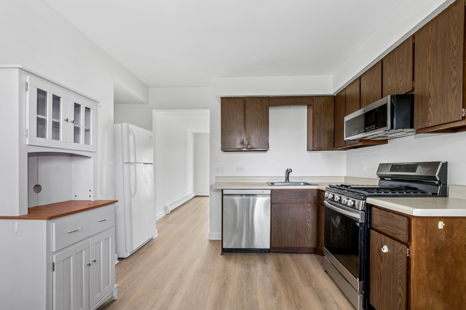 15290 El Cameno Terrace, Unit 2W Orland Park, IL 60462 - Photo 8 of 14 a kitchen with stainless steel appliances a stove sink microwave and cabinets