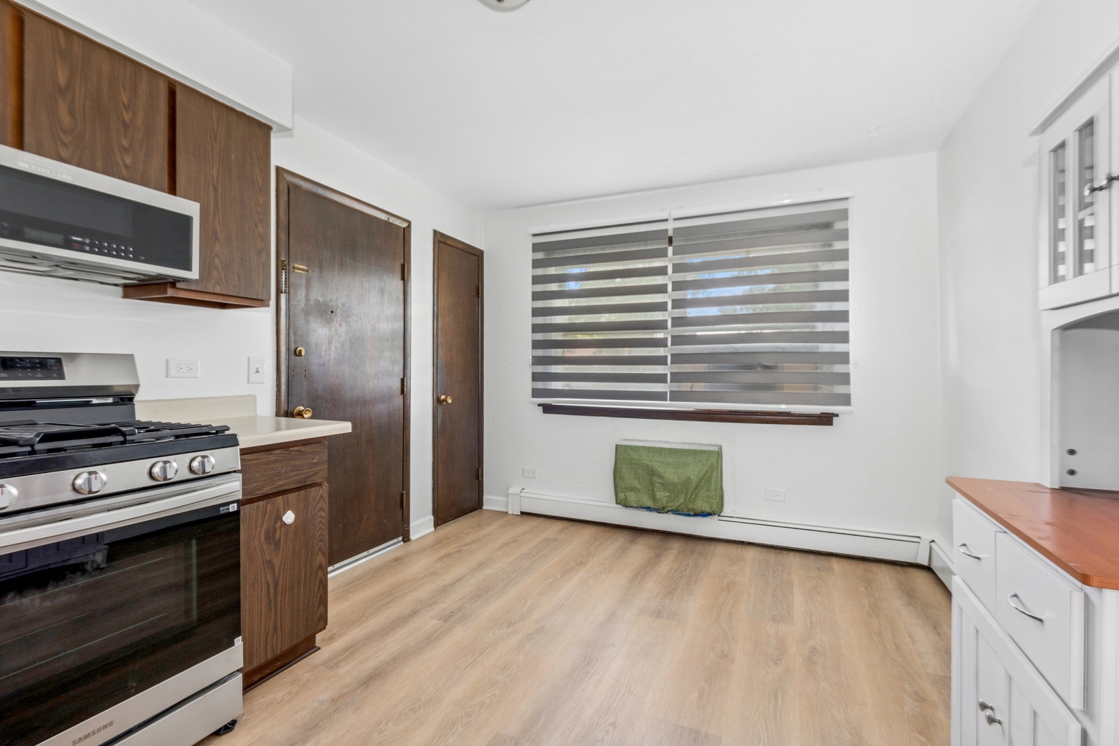 15290 El Cameno Terrace, Unit 2W Orland Park, IL 60462 - Photo 9 of 14 a kitchen with granite countertop a stove and a wooden floor
