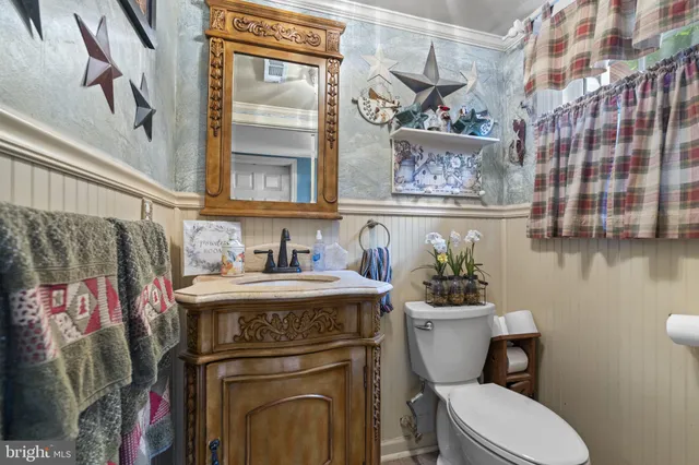 a view of bathroom with a sink a toilet and a mirror
