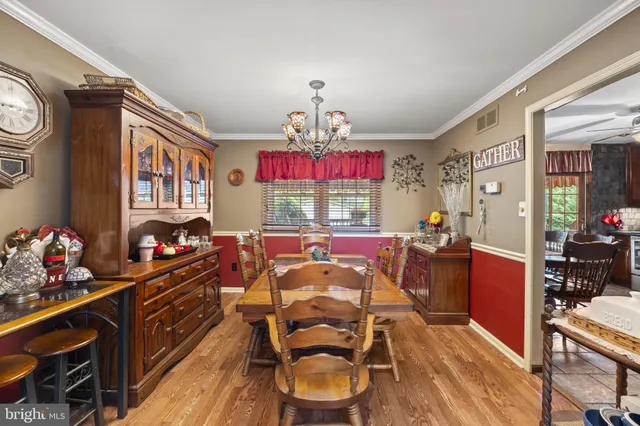 a view of a dining room with furniture a chandelier and wooden floor
