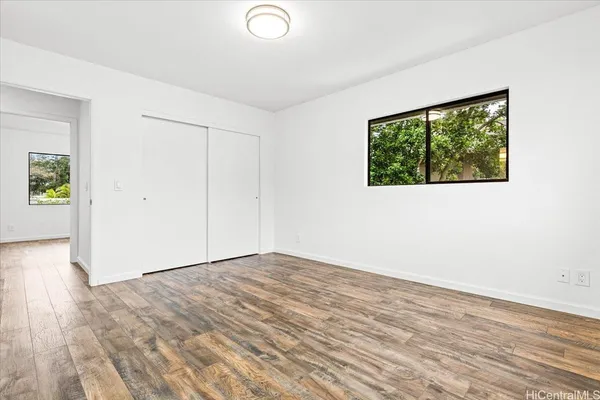a view of empty room with wooden floor