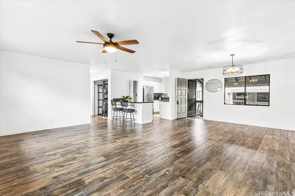 a view of empty room with wooden floor and fan