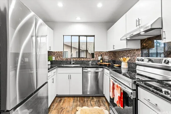 a kitchen with a sink stove and cabinets