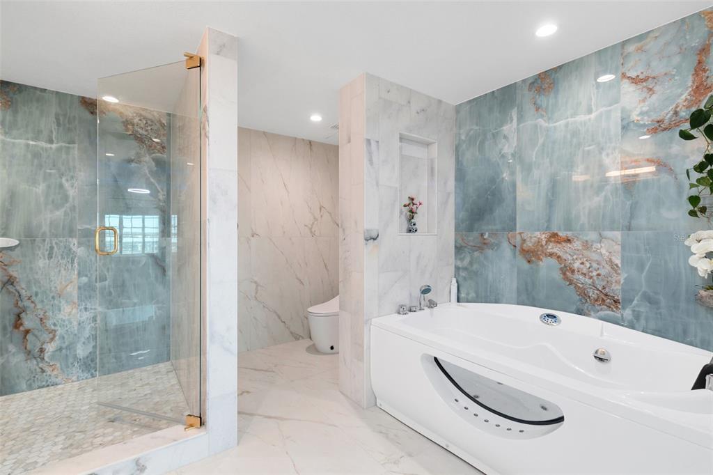 7593 Gathering Drive, Unit 802 Reunion, FL 34747 - Photo 17 of 34 a bathroom with a sink a toilet and shower