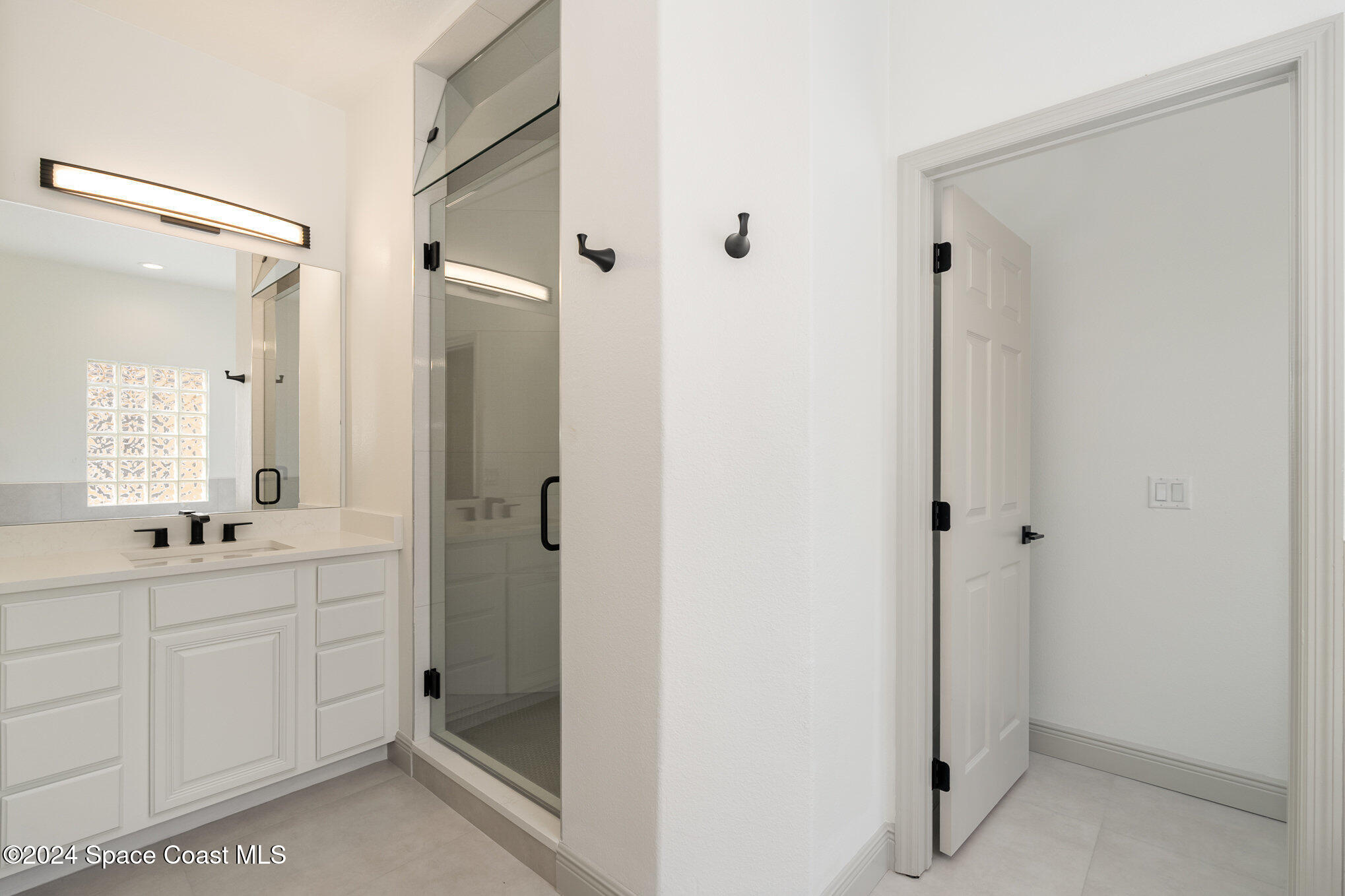 16 South Court Indialantic, FL 32903 - Photo 11 of 20 a bathroom with a double vanity sink a mirror and a shower